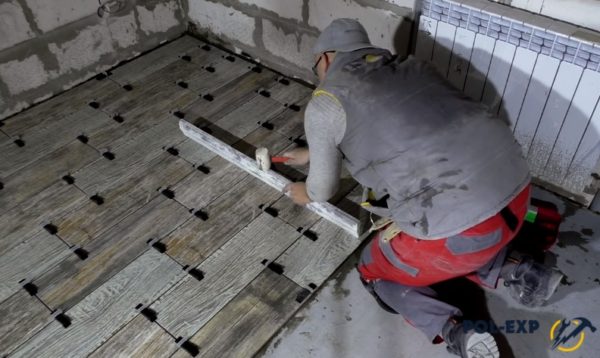 Проверка положения керамогранита и корректировка киянкой